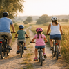 Familie mit zwei Kindern faehrt Fahrrad auf einem Feldweg im Sommer