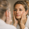 Frau vor einem Badezimmerspiegel in der Abendroutine