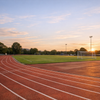 Sportplatz mit Laufbahn im Abendlicht