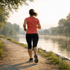 Joggerin auf einem Uferweg am Fluss im Sommer